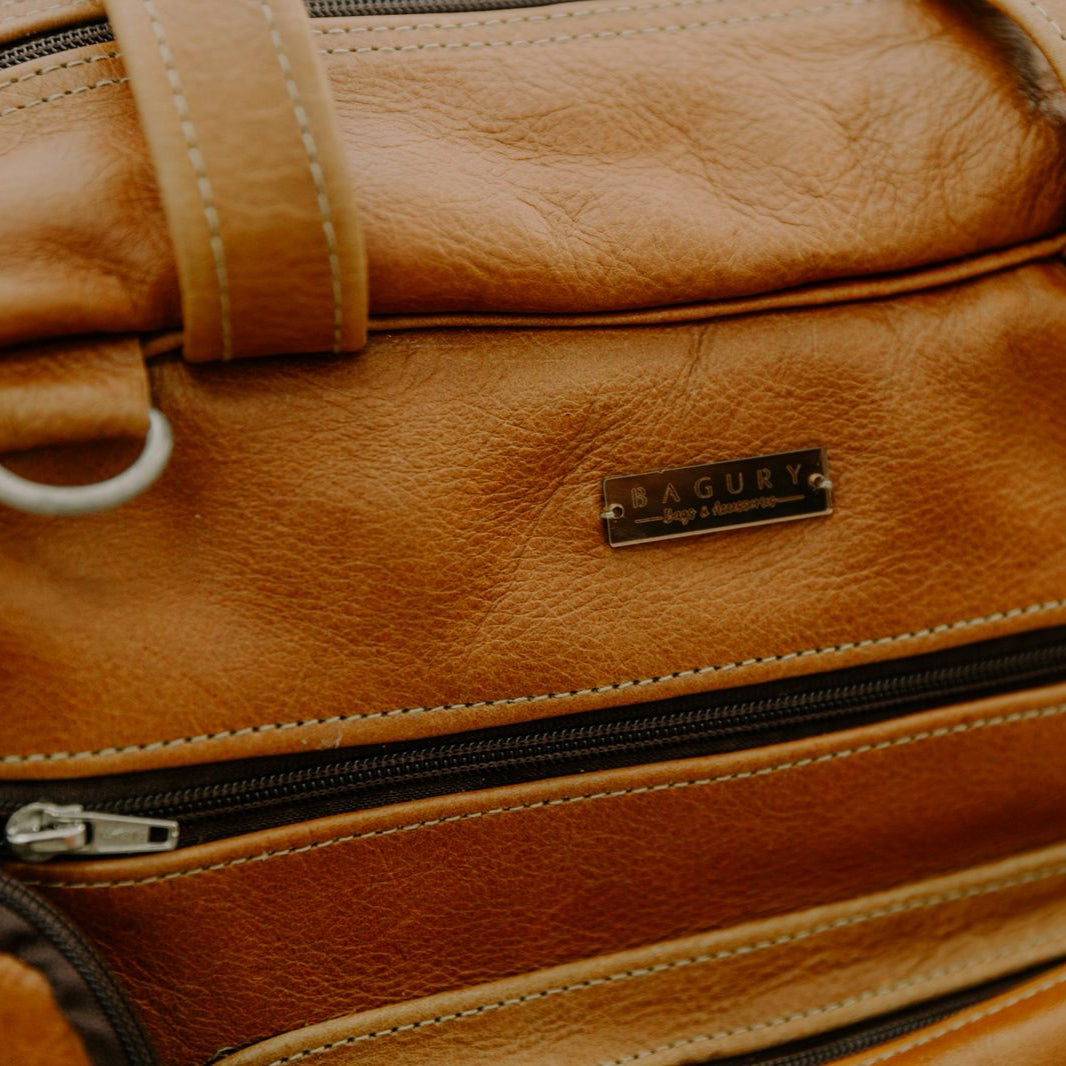 Close-up of a brown leather bag with a visible brand label.