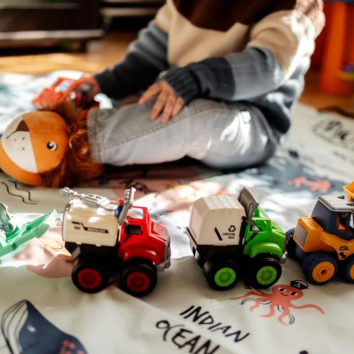 Child playing with toy trucks on a map
